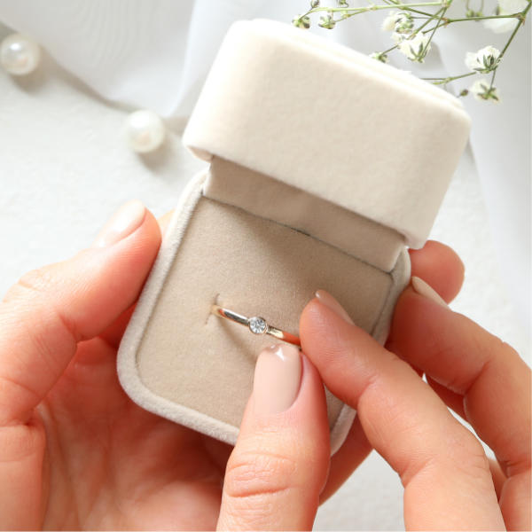 Lady taking an engagement ring out of a ring box